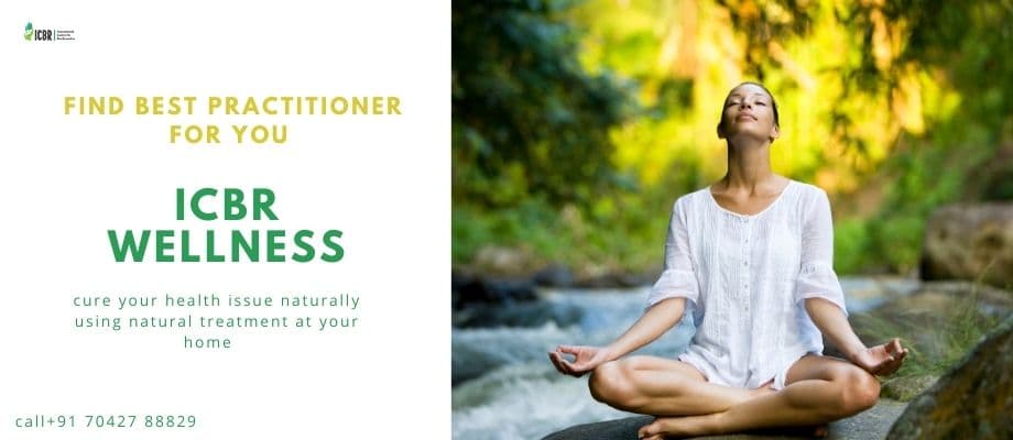 A person doing yoga on a home balcony with mountains and greenery at sunrise
